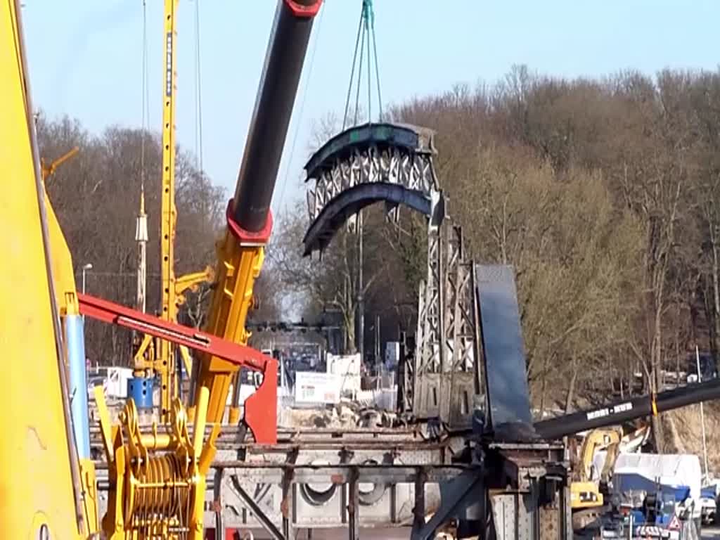 Video_Teil 3 von 3 // LIEBHERR Mobilkran LTM 11200-9.1 (?), LIEBHERR LTM 1500-8.1 (?) und CATERPILLAR CAT 323D im Einsatz. Während der Rückbauarbeiten kam ein weiterer schwerer Mobilkran der Fa. Mobi-Hub am Ostufer der Havel zum Einsatz. Da das Ostufer weiträumig für Zuschauer gesperrt war kann ich zu diesem Gerät leider nichts sagen. Einsatzgrund für die schweren Geräte war die endgültige Demontage der 106 Jahre alten Freybrücke über die Havel in Berlin-Spandau, OT Wilhelmstadt. Das Hauptfeld der Brücke wurde nach Sperrung der Havel (hier die Untere Havel-Wasserstraße) in nur 48 Stunden demontiert. Die Sperrung der Havel war notwendig, weil Pontons unter dem abzutragenden Brückenkörper verankert wurden. Das man auch unter Zeitdruck nicht in Hektik verfallen durfte, zeigen die Kranführer mit den tonnenschweren, pendelnden Brückenteilen am Haken. Für viele Zuschauer ergaben sich am Abend noch schöne Fotomotive als sich Schneidbrenner durch den Stahl fraßen und das geschmolzene Metall einem Vulkanausbruch gleich zur Erde stürzte. Video_Teil 3 von 3 vom 18./19./21.März 2015 